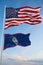 Large official Flag of US with smaller flag of Guam state, Usa at cloudy sky background. United states of America patriotic