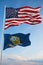 Large official Flag of US with smaller flag of Idaho state, Usa at cloudy sky background. United states of America patriotic