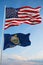 Large official Flag of US with smaller flag of Kansas state, Usa at cloudy sky background. United states of America patriotic