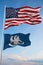 Large official Flag of US with smaller flag of Louisiana state, Usa at cloudy sky background. United states of America patriotic