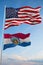 Large official Flag of US with smaller flag of Missouri state, Usa at cloudy sky background. United states of America patriotic