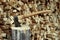 A large old ax sticks out of a wooden hemp block against a background of firewood.