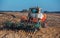 Large, old, beautiful tractor plowing the earth on the field after harvest autumn harvest sunflowers.