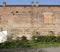 Large old brick wall with blind window and two directors parking signs