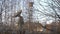 A large old radar at an old base in the middle of the forest