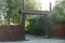 Large open brown gate and a picket fence