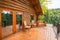 A large open wooden deck on a rustic log cabin home in the mountains of the American Northwest