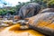 Large orange dyed rocks at Tidal River.