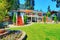 Large orange house with white trim. View of back yard with patio area.