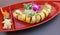 Large orange platter filled with the tempting array of sushi roll, ginger and wasabi garnish