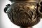 a large ornate vase with a gold decoration on it\\\'s side and a black background behind it, with a whi