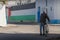 The large Palestinian flag (flag of Palestine) mural on the wall with the old man passing by with the bicycle