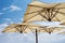 Large parasols. Beach season, time of rest and travel. Place for the text. Blue sky background. Beach umbrellas from the sun