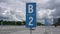 Large parking lot with grey asphalt and blue road signs