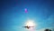Large passenger airliner landing flying through sun rays