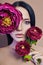 Large peonies near a woman face, art fashion flowers in front of a girl, nature face care, natural cosmetics