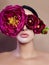 Large peonies near a woman face, art fashion flowers in front of a girl, nature face care, natural cosmetics