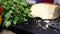 Large piece cheese with cheese knife on dark wooden cutting board, in domestic kitchen. And different vegetable tomato