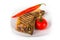 Large piece of fresh pork meat on a bone prepared on a grill pan and red hot chili pepper and tomato on a light background