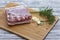 A large piece of pork belly on the cutting board. Juicy pieces of bacon with garlic, pepper and