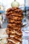 Large pieces of meat on a spit at street food market in Thailand. Crilled skewered chiken meat on spit. Fast food