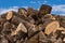 Large pile of firewood  blue sky and clouds