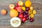 A large pile of fresh fruit on a wooden table - apples, plums, m