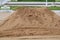 A large pile of sand laying on the outdoor area in the construction zone, building an industrial house building idea.