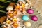 Large pink daffodils and biscuits on burlap with painted Easter eggs lie on straw carpet