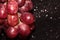 Large pink grapes on a black shiny background