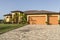 Large pink and yellow tropical house with circular driveway.