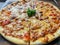 Large pizza pan with delicious tomatoes and cheese.Italian style pizza, thin crispy batter with tomatoes and cheese