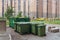 Large plastic garbage cans in the background of a huge apartment building