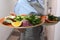 A large plate of salad and herbs in the hands of the waiter