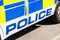 Large police sign on the side of a British patrol vehicle.