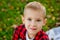 A large portrait of a boy in nature, in the park or outdoors. A child on a green background