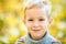 Large portrait of a boy in the open air. Cute boy walking in the autumn Park. The child looks at the camera with a smile