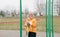 large portrait of an elderly woman with Scandinavian sticks in the stadium.