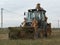 Large powerful tractor removes the earth works on construction site