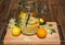 In the large preserving jar on the cutting board are the fresh elderflowers, oranges and lemon slices and the vanilla pod