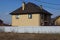 Large private brown brick house behind a gray metal fence