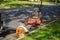 Large professional lawn mower and leaf blower in the street by a curb near a a trailer