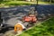 Large professional lawn mower and leaf blower in the street by a curb near a a trailer