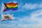 large progress lgbtq flag and flag of California state, USA waving in the wind at cloudy sky. Freedom and love concept. Pride