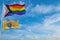 large progress lgbtq flag and flag of New Jersey state, USA waving in the wind at cloudy sky. Freedom and love concept. Pride