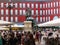 Large public walking next to the Monument of King Felipe III in the Plaza Mayor of Madrid