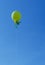 Large publicity balloon over blue sky - green, yellow, assorted