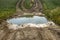 Large puddle of water on a gravel road