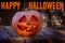 A large pumpkin with a smiling face and burning candles inside. Symbol Halloween in the twilight forest. Above is the