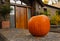 Large pumpkin standing at the front doors outside of the fancy home. Season outdoor decoration for the halloween in USA